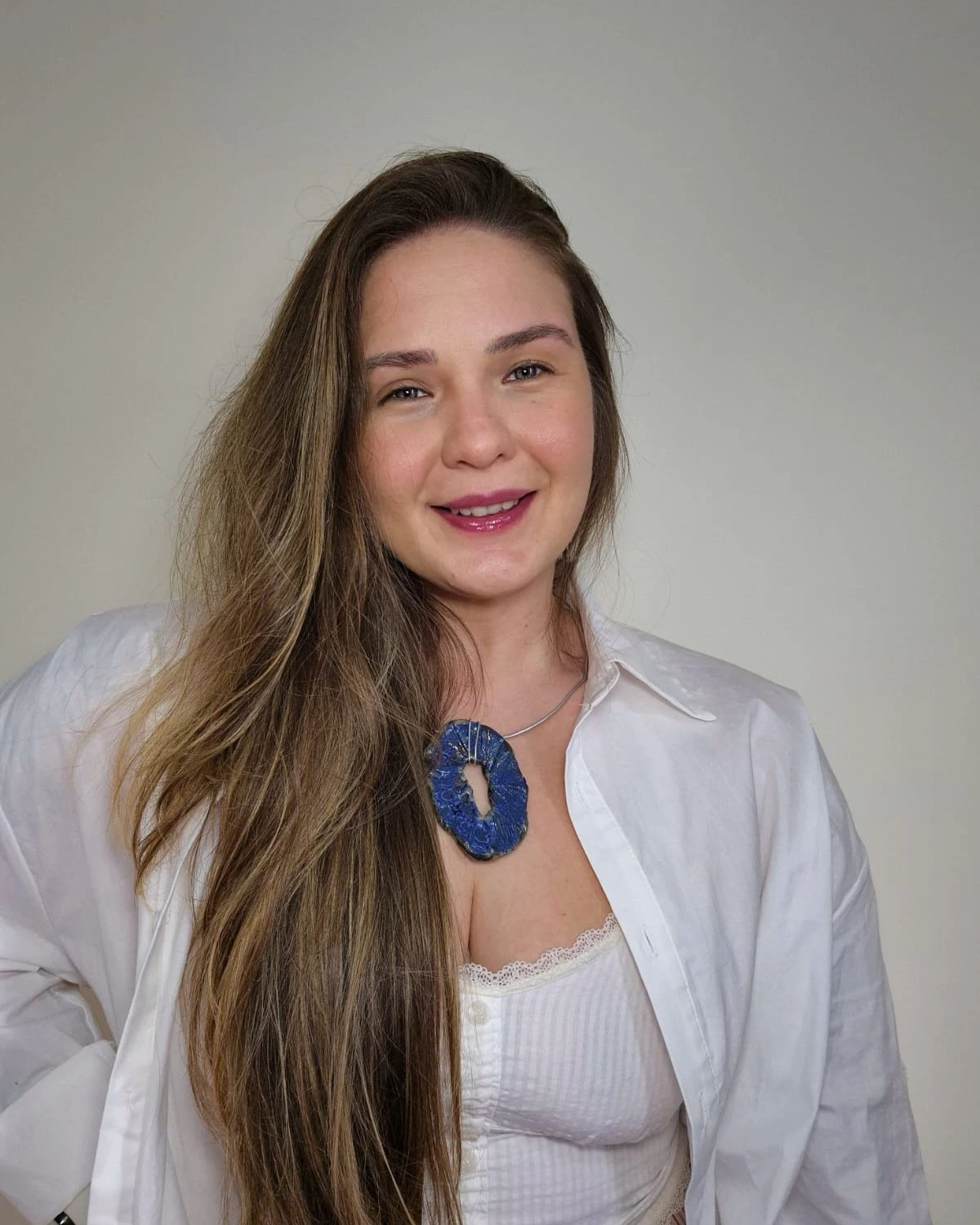 Nathália Braz de camisa branca, braços cruzados, com tatuagens à mostra
